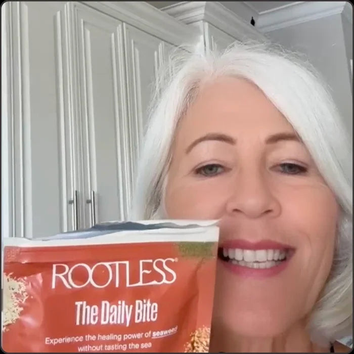 Woman holding a Rootless Daily Bite pouch